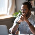 Student smiling at laptop